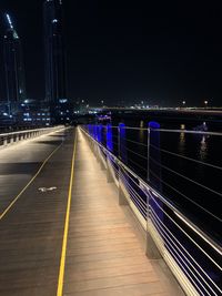 Illuminated bridge over road in city at night