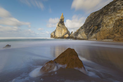 Rock formations in sea against sky