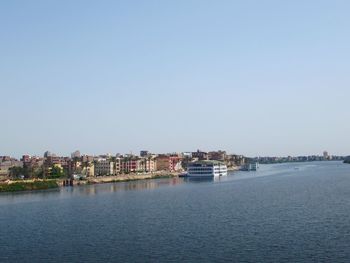 Scenic view of sea by buildings against clear sky