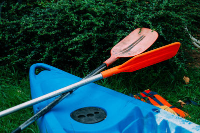 High angle view of kayak and oars on field