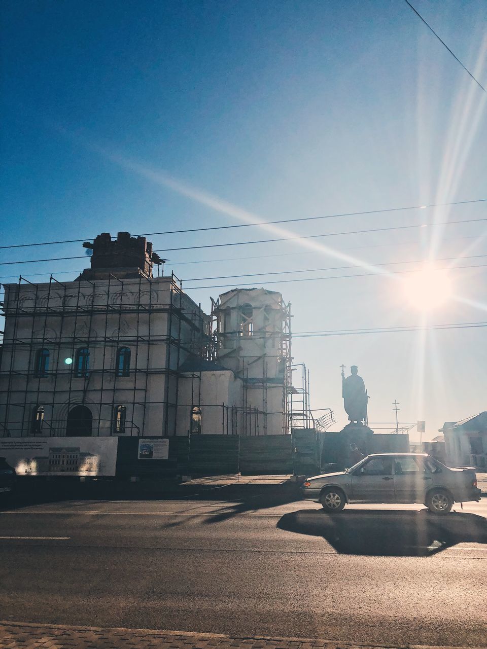 CARS ON STREET BY BUILDINGS AGAINST SKY