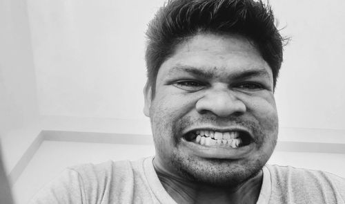 Close-up portrait of smiling young man at home