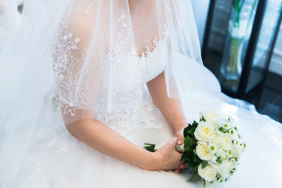 Midsection of woman holding bouquet