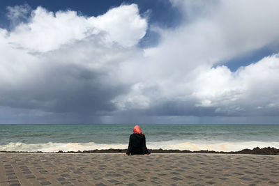 Rear view of woman looking at sea against sky