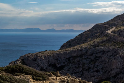 Scenic view of sea and mountains against sky