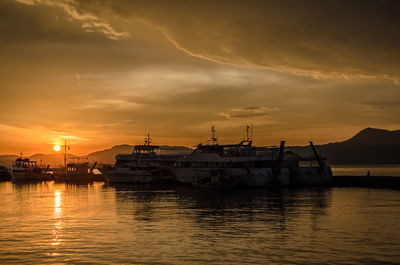 Boats at harbor during sunset