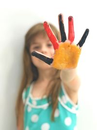 Close-up of girl hand with paint against white background