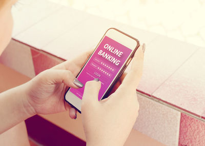 Close-up of woman using mobile phone for online banking