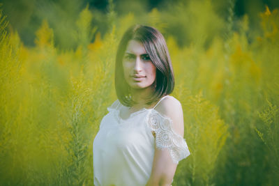 Portrait of woman standing against plants