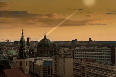 Communications tower in city at sunset