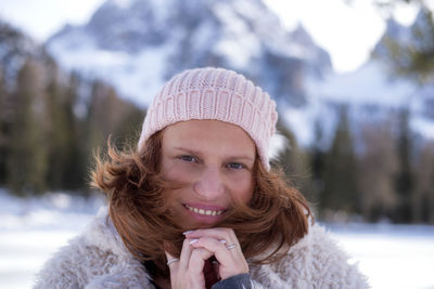 Close-up portrait of mature woman wearing warm clothing and knit hat during winter
