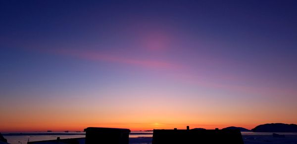 Silhouette buildings against sky during sunset