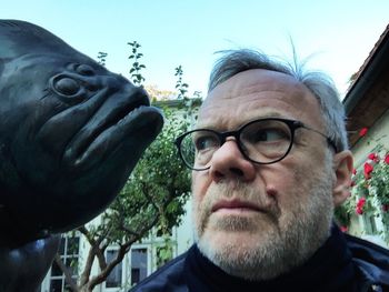 Close-up portrait of man against sky