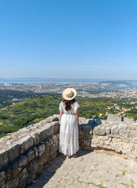 Rear view of woman standing on hill at klis fortress above city of split in croatia