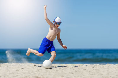 Full length of man playing with ball on beach