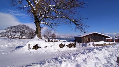 Snow covered field against clear blue sky