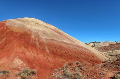 Scenic view of desert against clear blue sky