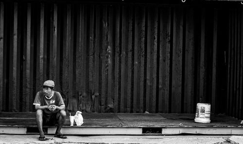 Full length of man sitting outdoors