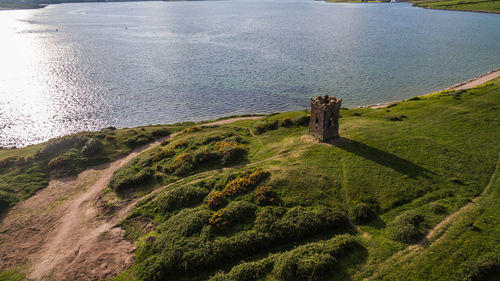 High angle view of grass by sea against sky