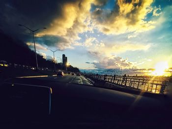 View of road against cloudy sky at sunset