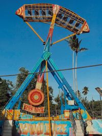 Low angle view of ferris wheel against blue sky