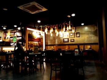 Empty chairs and tables in cafe at night