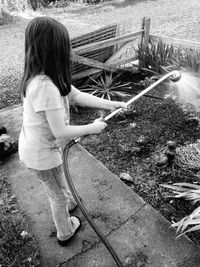 Girl watering plants in yard