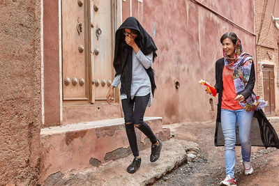 Women standing against graffiti wall