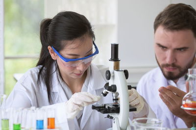 Scientists with microscope experimenting in laboratory 