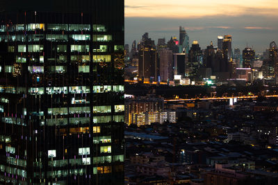 Illuminated buildings in city against sky at night