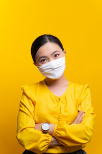 Portrait of a woman against yellow background