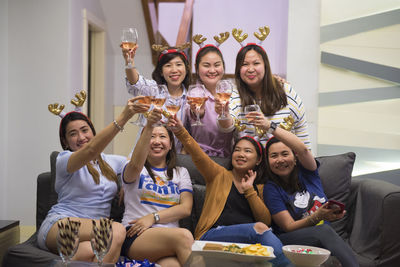 Portrait of smiling young woman sitting on sofa