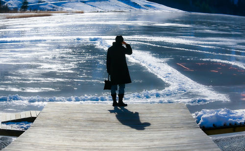 Rear view of man standing on snow