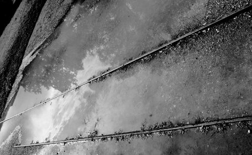 Low angle view of wet metal against sky