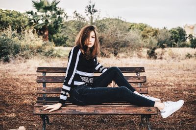 Portrait of young woman sitting on land