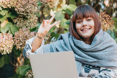 Portrait of young woman using laptop at home