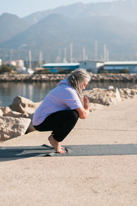 Side view of woman sitting on beach