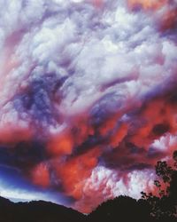 Close-up of pink clouds over landscape against dramatic sky