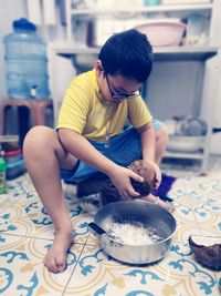 Rear view of boy preparing food at home