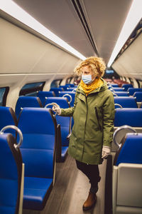 Full length of woman standing in train