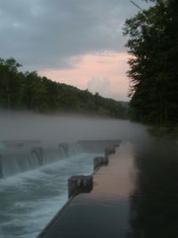 Scenic view of river against cloudy sky