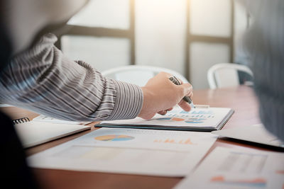 Cropped image of business person working over graph in office