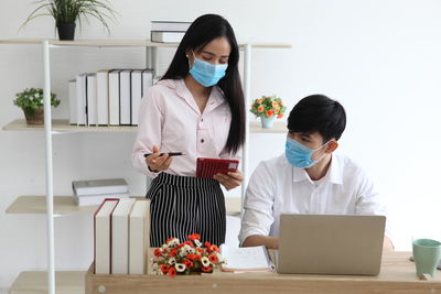 Young couple standing on table at home