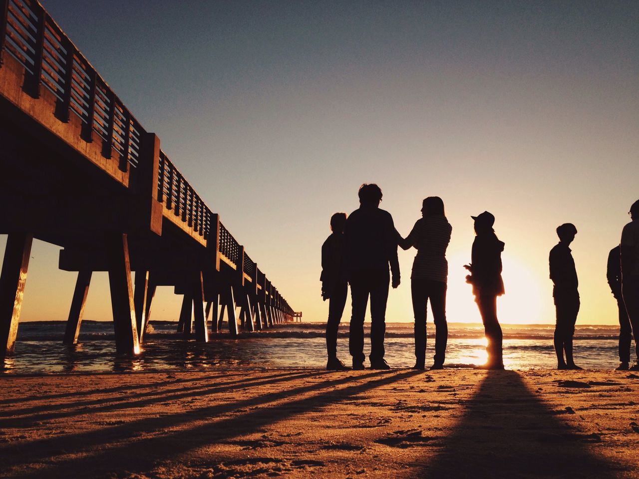 men, silhouette, sunset, clear sky, lifestyles, togetherness, copy space, walking, full length, person, leisure activity, sky, standing, rear view, friendship, sunlight, outdoors, medium group of people