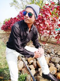 Young man wearing sunglasses while sitting outdoors