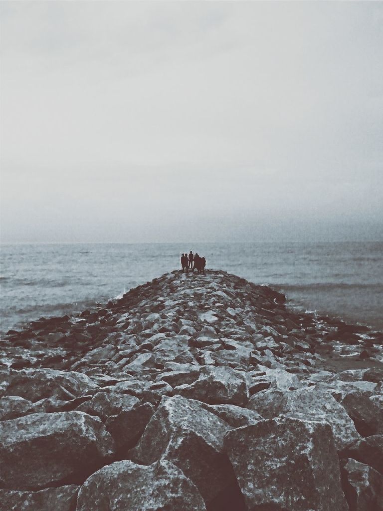 sea, horizon over water, water, beach, sky, lifestyles, shore, men, leisure activity, scenics, nature, tranquility, tranquil scene, beauty in nature, rock - object, dog, sitting