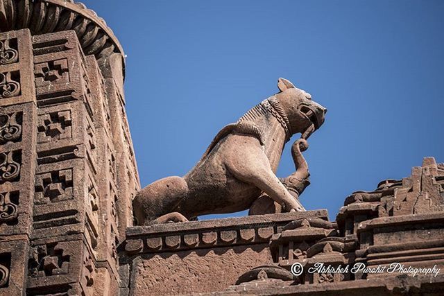 clear sky, statue, sculpture, architecture, low angle view, art and craft, built structure, art, building exterior, human representation, blue, creativity, history, animal representation, copy space, famous place, travel destinations, carving - craft product, travel
