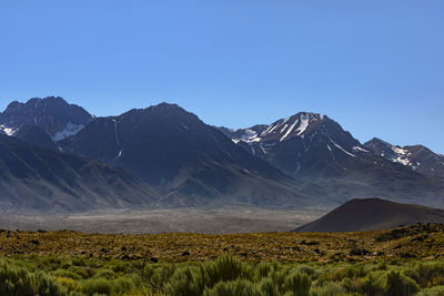 Scenic view of mountains against clear blue sky