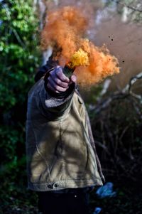 Man holding flowers while standing with distress flare on field