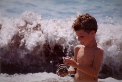 Full length of shirtless boy on beach